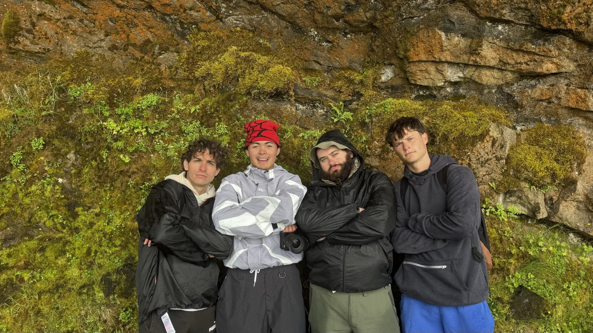 The Real Treasure crew gathered against a mossy cliff in Iceland