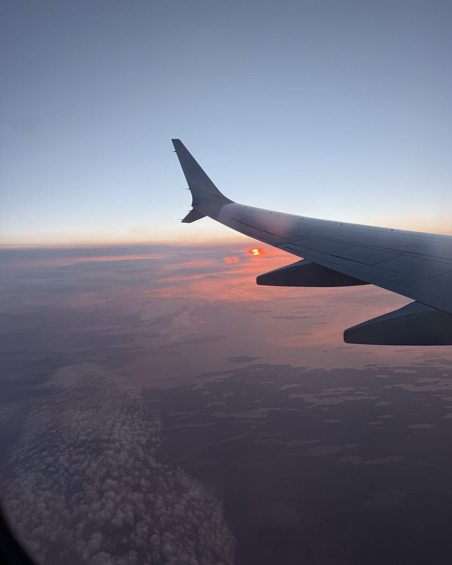 Sunset over the clouds from the plane window on the way to Iceland