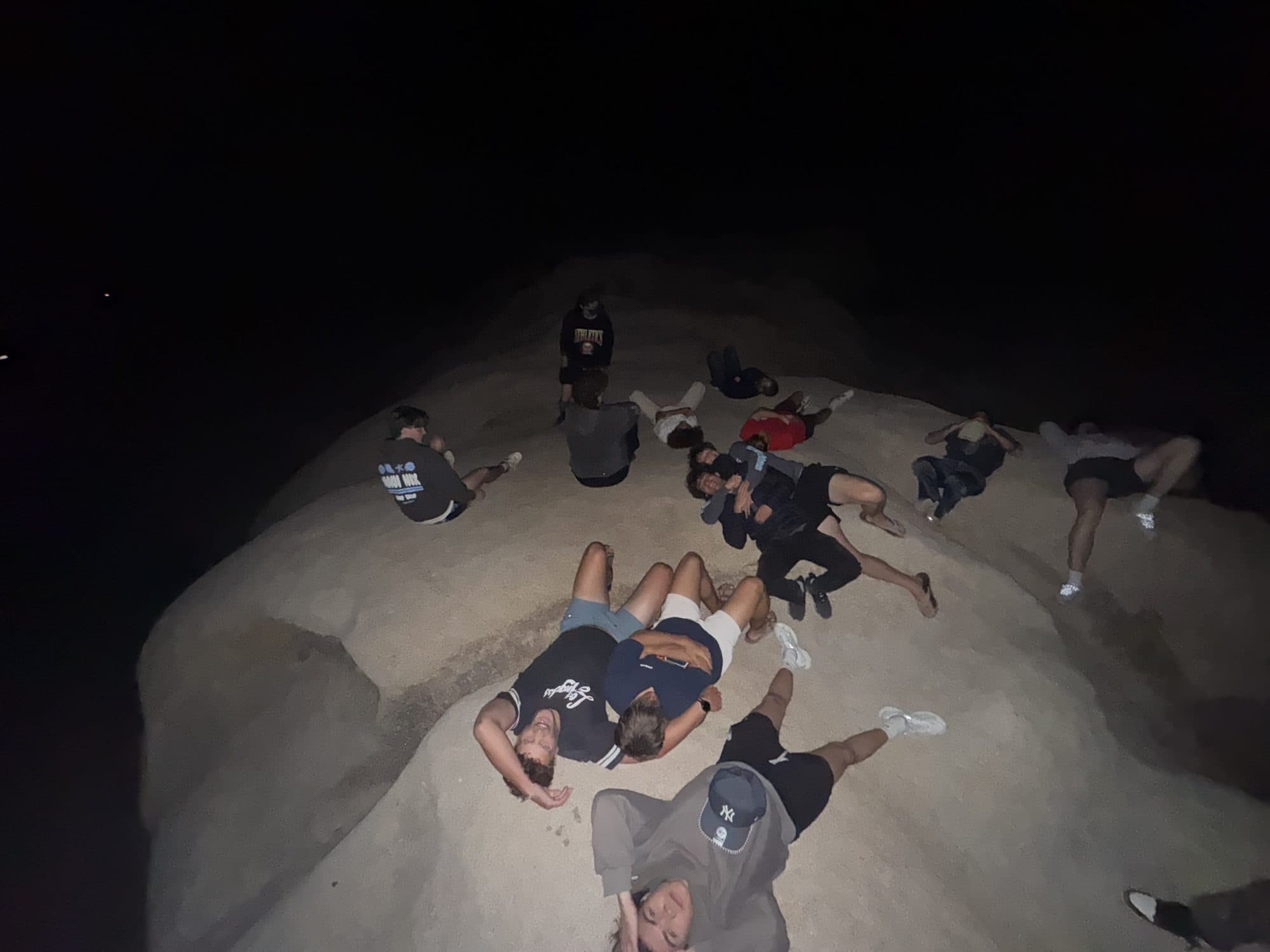 The cohort lying on the rocks under the night sky